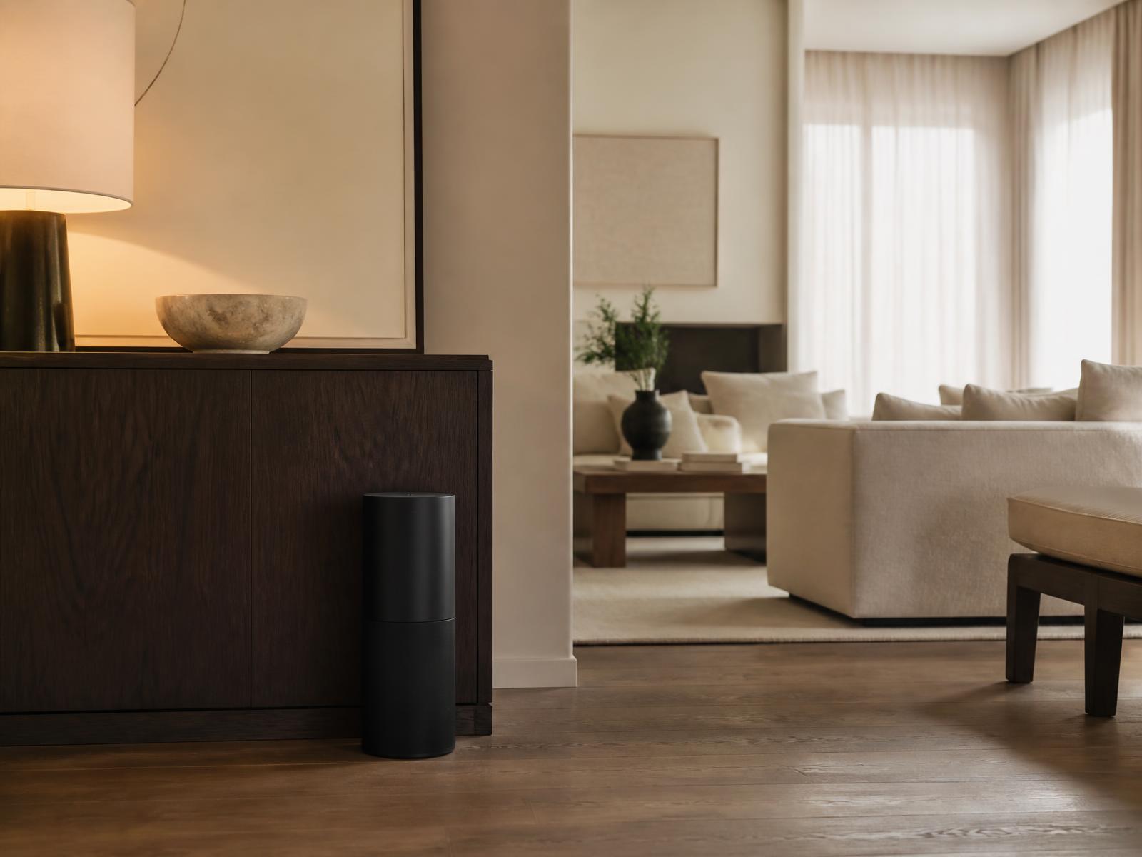 Matte black scent system beside an oak console in an open-plan living room
